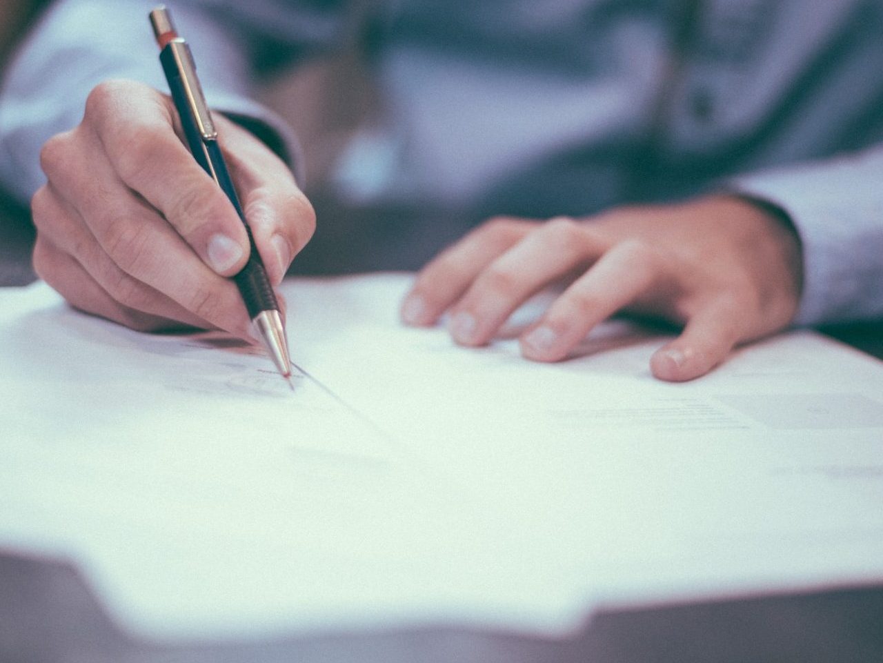man writing on paper